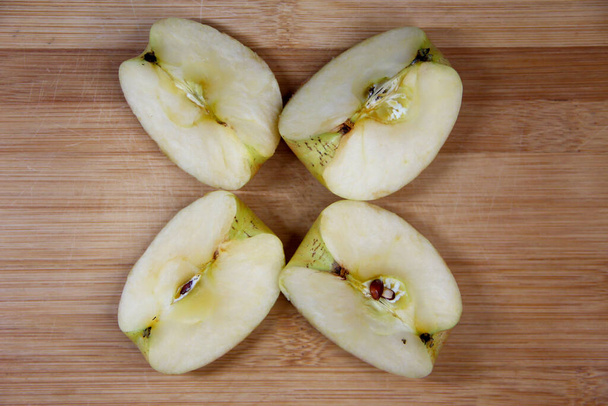 Чотири шматочки яблука на дерев'яному фоні
 - Фото, зображення