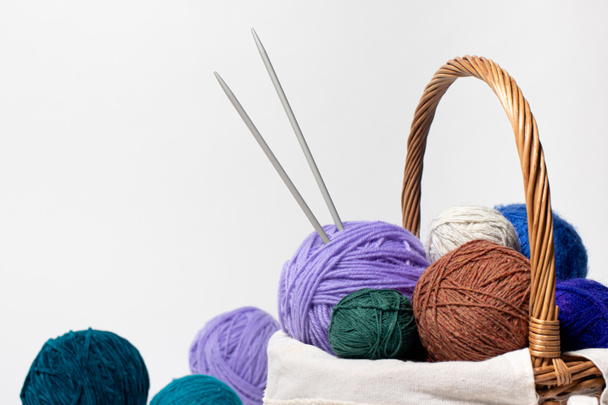 Knitting Yarn Balls And Needles In Basket On A White Background