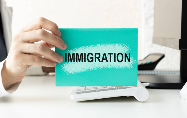 An immigration worker holds a notepad that says immigration. - 写真・画像