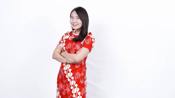 Cheongsam elbiseli Asyalı Çinli kadın Çin Yeni Yılı 'nı kutluyor. Mutlu Çin Yeni Yılı, yalnız ve arka planda - Fotoğraf, Görsel