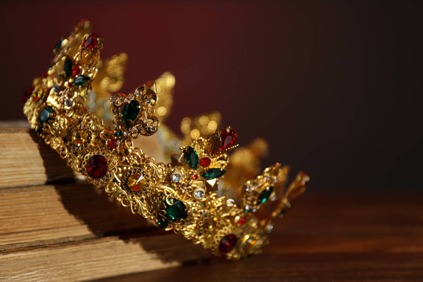 Beautiful golden crown and old books on wooden table. Fantasy item - Φωτογραφία, εικόνα