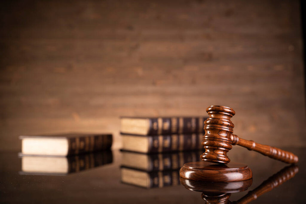 Jogi téma. Bírák kalapács és gyűjtemény jogi könyvek barna háttér.  - Fotó, kép