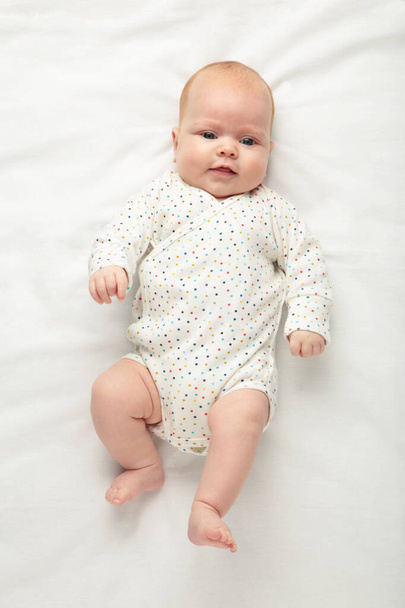 Cute baby girl in bed with copy space. Top view - Foto, imagen