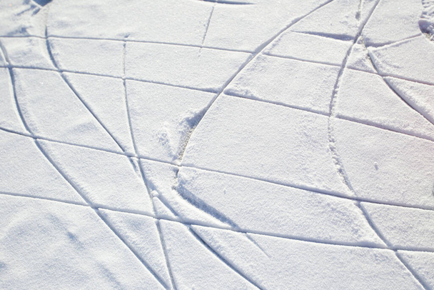 Bruslařské stopy na ledu se sněhovým sněhem. Zimní pozadí. - Fotografie, Obrázek