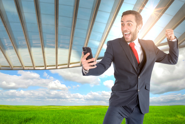 Homme d'affaires heureux ou courtier en valeurs mobilières avec téléphone mobile en plein air - Photo, image