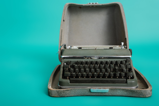 retro typemachine in open kast op turquoise achtergrond - Foto, afbeelding