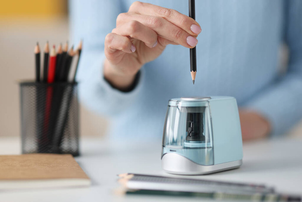 Kobiece ręce wystające ołówek w elektronicznym zbliżeniu temperówki - Zdjęcie, obraz