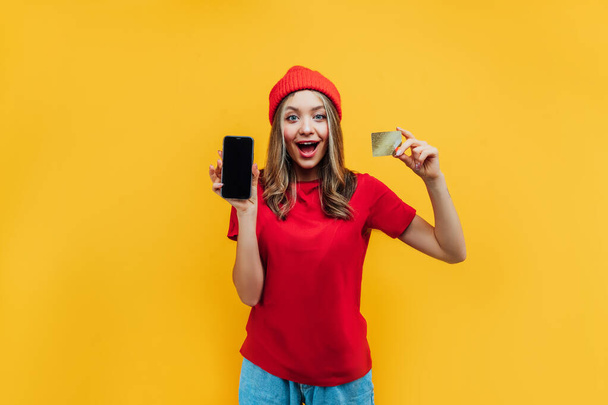 On a yellow background, a stylish girl in a red hat and red T-sh - Valokuva, kuva