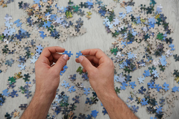 Man playing with puzzles on floor, top view - Photo, Image