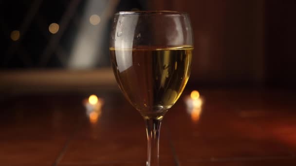 Glas witte wijn op tafel met bokeh verlichting achtergrond - Video