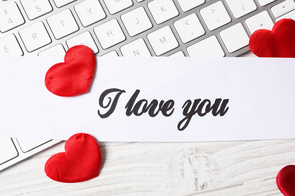 Card with text I Love You, red hearts and keyboard on white wooden background, flat lay - Photo, Image