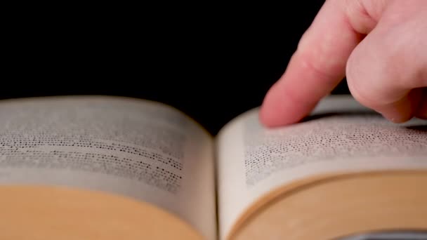 Kaukasischer weißer Finger sucht ein Wort in einem Buch und tippt darauf. - Filmmaterial, Video