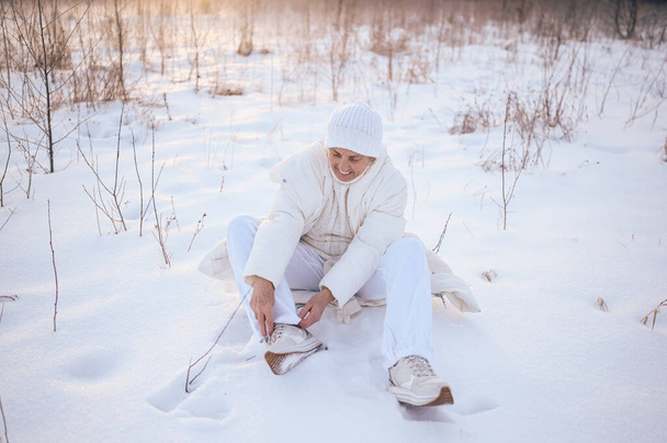 Šťastný starší starší starší žena v bílém teplé oblečení hrát se sněhem ve slunné zimě venku. Zdraví důchodci dovolená dovolená zimní aktivity, aktivní životní styl koncept - Fotografie, Obrázek