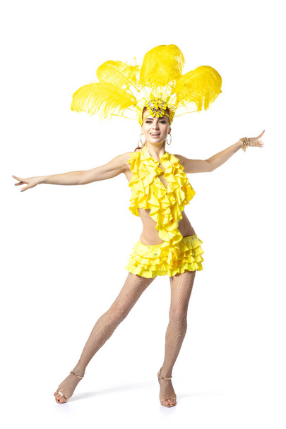 Krásná mladá žena v karnevalu, stylový maškarní kostým s peřím tančí na bílém pozadí studia. - Fotografie, Obrázek