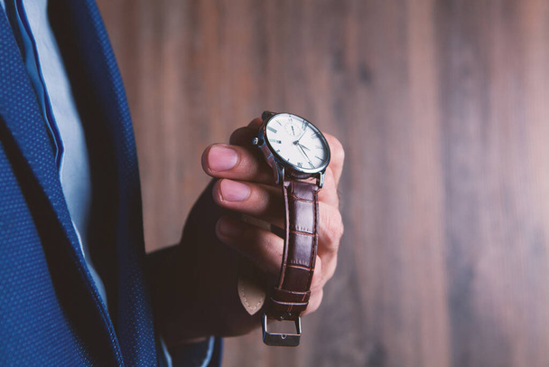 young man puts on a wristwatch - Fotó, kép