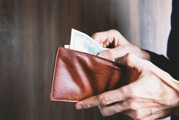 businessman holds wallet in his hands and counts money - Fotó, kép