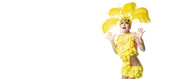 Beautiful young woman in carnival, stylish masquerade costume with feathers dancing on white studio background. - Фото, изображение