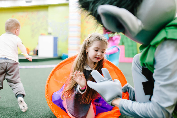 Happy childrens, girl is running and playing in the children's play room on her birthday party in kids amusement park and play center indoor. Celebration concept holiday, entertainment. - Fotó, kép