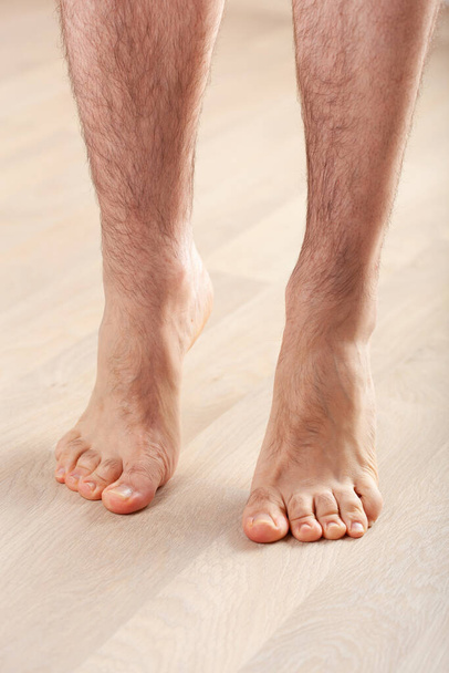 homem fazendo exercício de ginástica de correção flatfoot em pé sobre os dedos dos pés em casa - Foto, Imagem