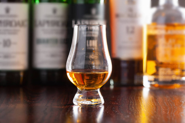 Pullot ja lasi viskiä tislattu alkoholijuoma tummanruskealla pohjalla - Valokuva, kuva
