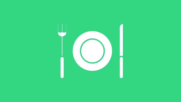 Witte plaat, vork en mes pictogram geïsoleerd op groene achtergrond. Bestek symbool. Restaurant bord. 4K Video motion grafische animatie - Video