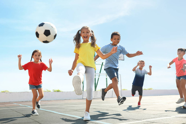 Cute children playing soccer outdoors on sunny day. Summer camp - Φωτογραφία, εικόνα