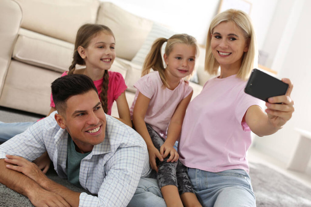 Happy family taking selfie on floor at home - Foto, Imagen