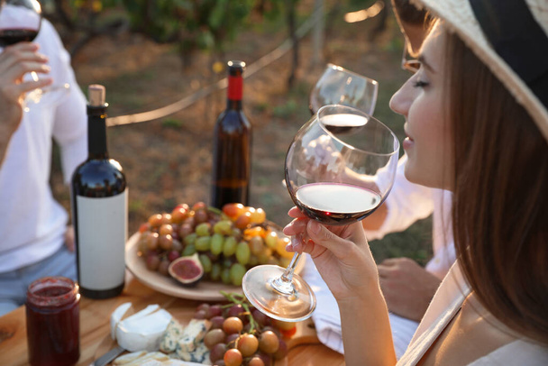 Friends holding glasses of wine and having fun in vineyard, closeup - Φωτογραφία, εικόνα