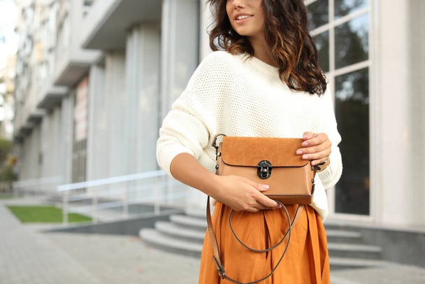 Young woman with stylish brown bag on city street, closeup - Valokuva, kuva
