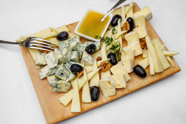 Tasting cheese dish on a wooden plate. - Fotó, kép