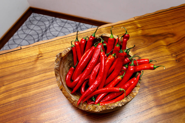 Piros chili paprika tányéron a fa asztalon - Fotó, kép