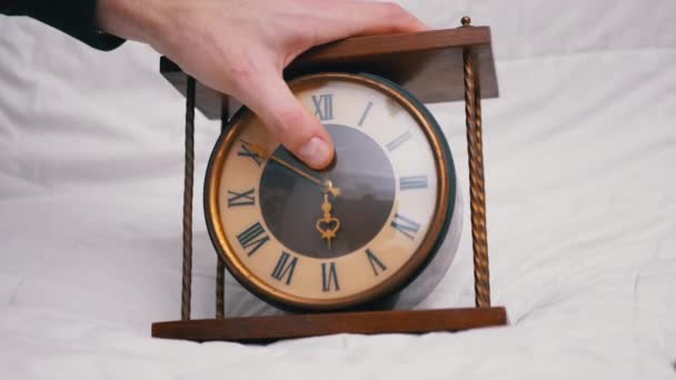 Мужчина держит старинные классические деревянные настольные часы с римскими цифрами. 4K - Кадры, видео