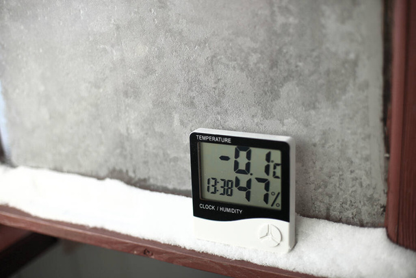 雪の上には温度と湿度の制御用の電子温度計と湿度計が設置されています。デバイスの湿度計に湿度表示が表示されます。 - 写真・画像