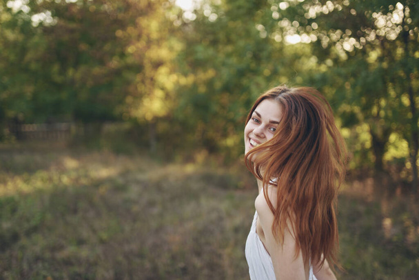 草原や木の緑の草の上に幸せな女性が走る背景には - 写真・画像