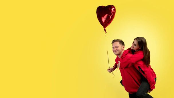 Beautiful couple in love on yellow studio background. Valentines Day, love and emotions concept - Photo, image