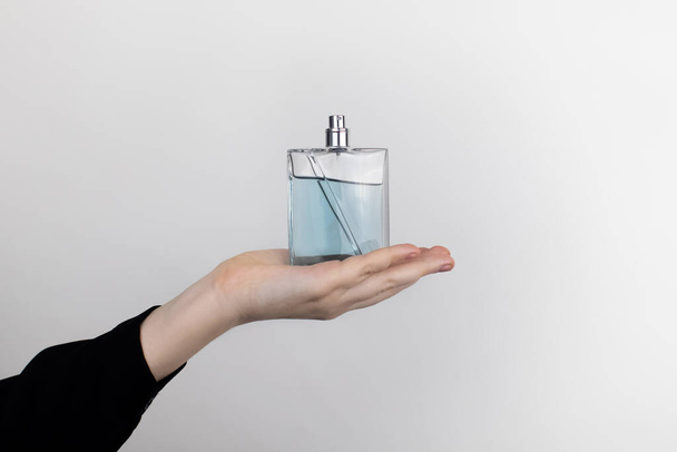 Bir kadın parfüm tutuyor. Mesajın için yer aç. Kozmetik ve ev kimyasallarında tehlikeli maddeler kavramı - Fotoğraf, Görsel