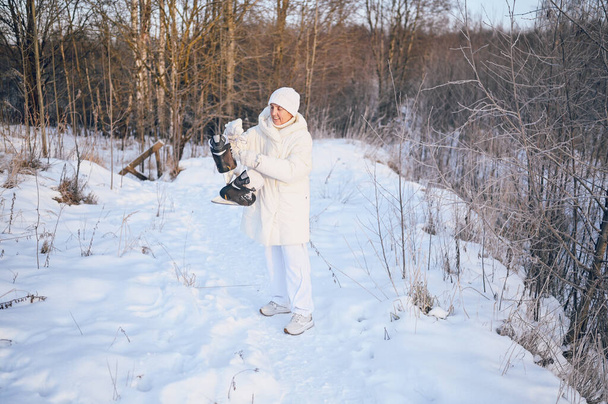 Boldog idős idős, érett nő fehér meleg fehérneműben játszik korcsolyával a napos havas téli szabadban. Nyugdíjas egészséges emberek nyaralás téli tevékenységek, aktív életmód koncepció - Fotó, kép