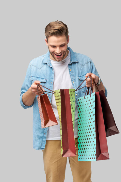 Portrait of a handsome young man with shopping bags - Foto, Imagen