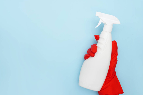 Υπηρεσία καθαρισμού Χέρι εργαζόμενος με λευκό μπουκάλι σε μπλε φόντο με αντίγραφο χώρου - Φωτογραφία, εικόνα