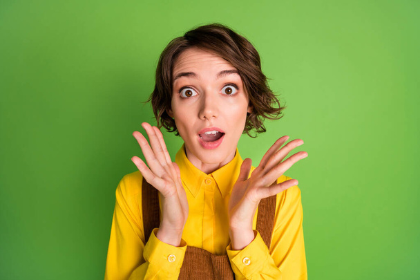 Photo of excited surprised girl palms face wear yellow shirt overall isolated green color background - Foto, Imagen