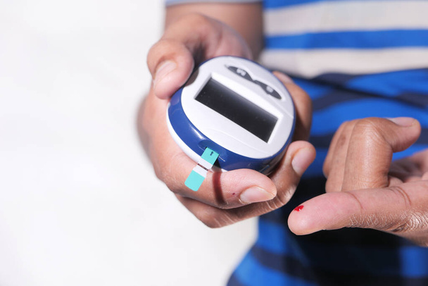 закрытие мужчин руки диабетической проверки уровня сахара в крови изолированы белый  - Фото, изображение