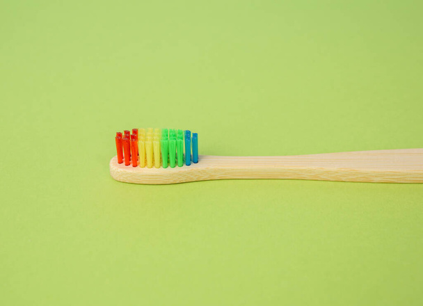 Yeşil arka planda diş temizlemek için bambu fırçası, plastik reddetme konsepti, sıfır atık, kapat - Fotoğraf, Görsel