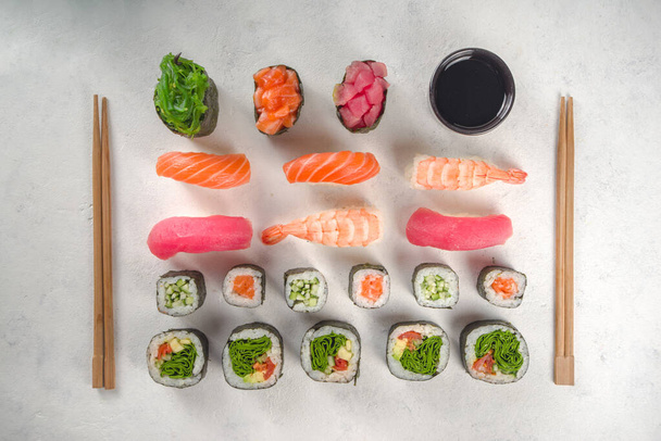  Conjunto japonês de sushi de frutos do mar. Vários rolos de sushi e sushi no fundo branco. Vista superior com espaço de cópia para texto - Foto, Imagem