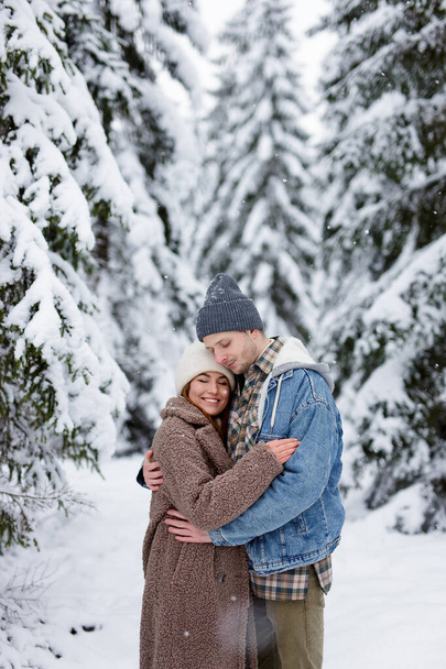 πορτρέτο του χαριτωμένο ζευγάρι αγκαλιάζει το χειμώνα δάσος ή πάρκο - Φωτογραφία, εικόνα