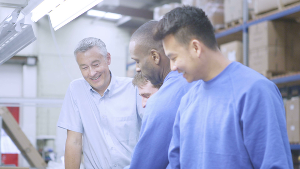 Щасливий чоловічий завод співробітників змішаної етнічної приналежності зі своїм лінійним менеджером
 - Кадри, відео