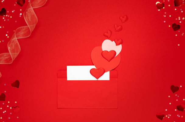 Ευτυχισμένη ημέρα του Αγίου Βαλεντίνου. Ερωτικό γράμμα με φάκελο και πολλές διαφορετικές καρδιές σε κόκκινο φόντο - Φωτογραφία, εικόνα