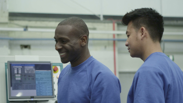 Happy mixed ethnicity team of machine operators in a factory - Footage, Video