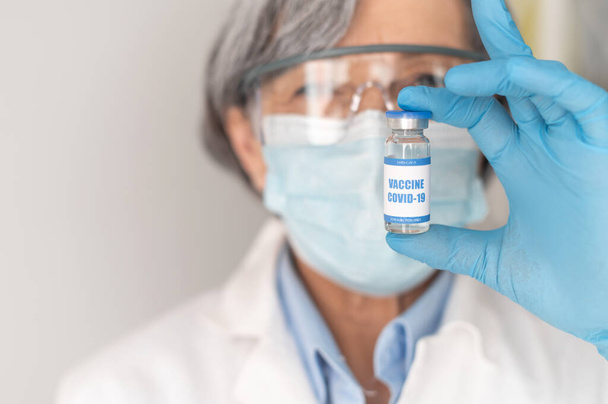 Close-up of a doctor holding coronavirus vaccine - Foto, afbeelding