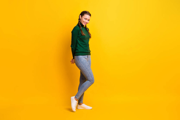 Full length body size photo of shy girl with braids in casual outfit smiling isolated on vivid yellow color background - Fotó, kép