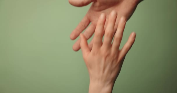 помочь другу пережить трудные времена. спасательный жест. руки тянутся вместе на зеленом фоне - Кадры, видео